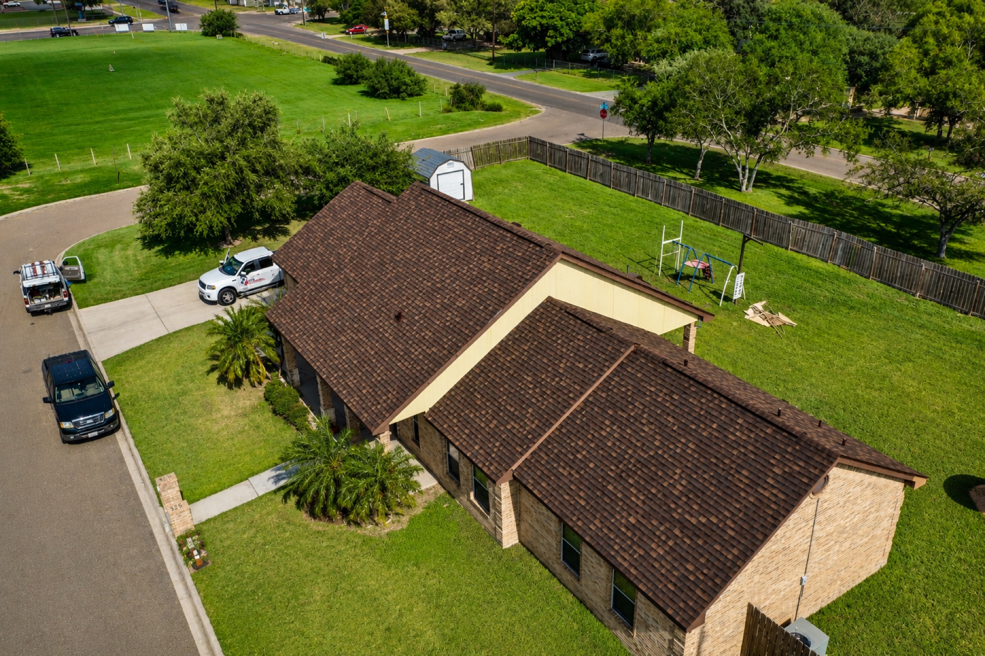 Drone view of a completed brown architectural shingle roof on a Rio Grande Valley brick home